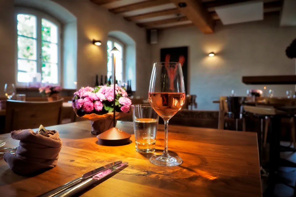 Restaurant mit Holzbalken, Kerzenlicht und Roséwein
