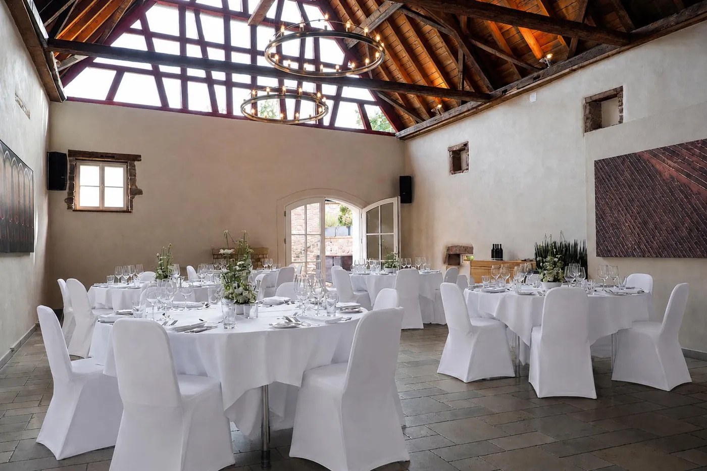 Scheune bei Tageslicht mit runden Hochzeitstischen